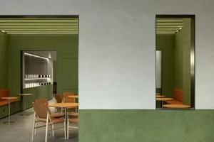 Modern cafe interior with green tiled walls and wooden furniture.
