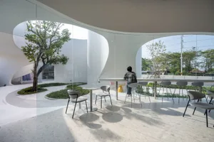 A modern restaurant bar with glass walls and white interior features.