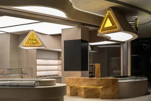 A modern restaurant interior with concrete and natural stone features.