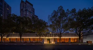 A night-time photograph of a modern building with a metal cladding exterior.