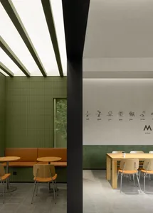 A modern industrial cafe space with a booth seating area.