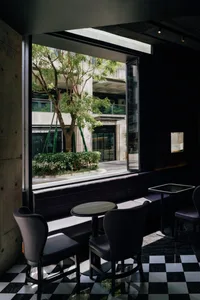 Modern cafe interior with glass wall, black table, and white flooring.