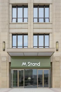 Modern restaurant entrance with stone exterior and large glass doors.