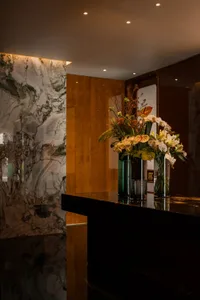 A modern reception desk featuring marble and wooden panels.