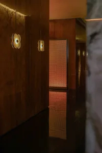 Modern corridor featuring a wooden floor with a textured, illuminated pattern, creating an elegant and sophisticated atmosphe