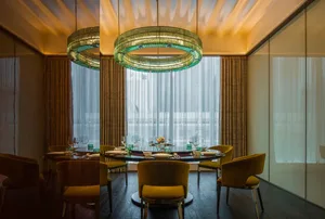 Modern dining room featuring round glass and metal chandeliers.