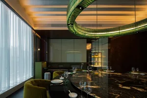 Modern restaurant interior with marble and glass materials.
