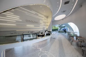 Modern minimalist coffee shop with a stylish gray concrete countertop and ambient lighting.