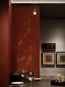 Industrially styled restaurant interior with red wallpaper and painted gold fish