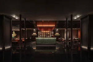 Interior of a minimalist restaurant with a marble bar, wooden tables, and metal chairs.