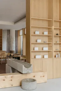 A minimalist retail space featuring wooden shelves with products displayed.