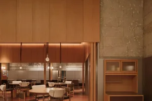 Modern cafe interior featuring wooden tables and chairs alongside concrete walls and floors.