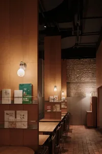 Modern cafe interior with wooden tables and shelves.
