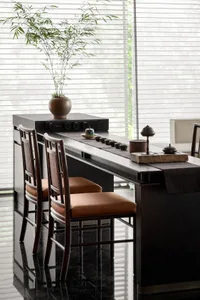 A modern interior scene featuring a sleek, dark wooden desk with a minimalist design, sitting chairs with brown cushions, and