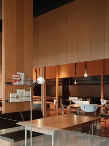 Modern interior design of a restaurant cafe with wooden tables and chairs, natural lighting, and minimalist decor.