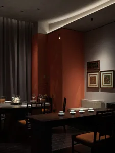 A modern restaurant interior featuring wooden tables, glass decorations, and fabric seating.