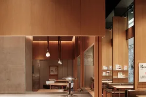 A modern restaurant interior with wooden walls and reflections.