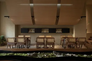 A modern restaurant interior designed with wooden elements and a tranquil greenery feature.