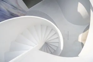 A minimalist white staircase rendered in a concrete-like material.