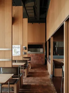 Industrial-style coffee shop with wooden materials and brick accent wall.