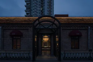 A view of a modern storefront with a brick facade at night.
