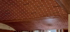 Industrial interior design featuring a brick ceiling with a central lamp.