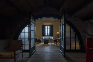 Interior design featuring a minimalist living room with brick arches and glass doors.