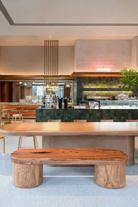 Industrial-style cafe interior featuring green tiles and wood furniture.