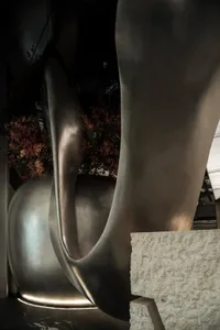 A modern interior space featuring metallic sculptures and plants.