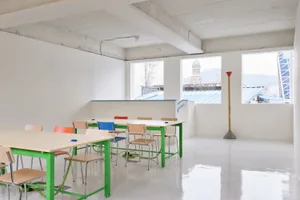 Minimalist classroom with green-framed tables and chairs