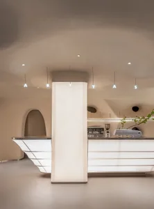Lobby with sleek, white concrete coffee shop counter and minimalist design elements.