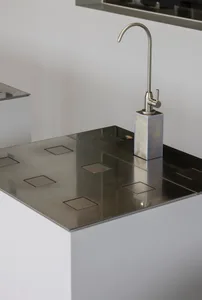 Modern kitchen featuring a metal countertop with integrated sink and faucet.