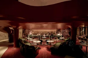 Modern restaurant and bar interior with metallic walls and tables.