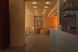A modern restaurant interior with concrete and wooden materials.