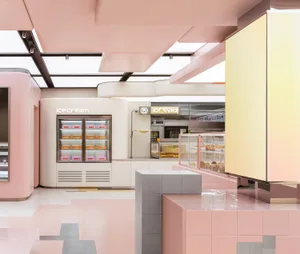 A minimalist cafe shop interior featuring pastel pink tiles on the floor and walls, with a counter displaying various pastrie