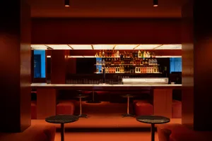 Industrial-style restaurant bar with metallic tables and barstools