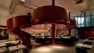 A modern industrial-style restaurant interior with a metal bar counter.