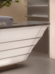 A sleek, modern reception desk with metallic surfaces and minimalist design.