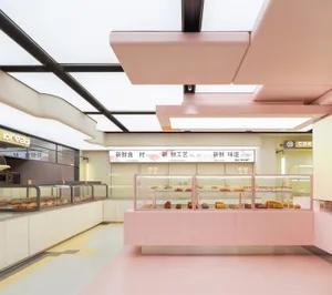 Modern bakery shop with pink tiled walls and acrylic storefront display cases showcasing fresh baked goods.