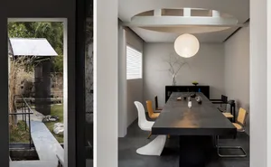 A minimalist dining room with a large concrete table and metal chairs.