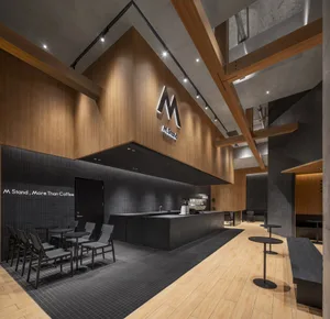 A modern industrial coffee shop with wooden walls and black accents.