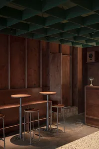 Industrial style cafe interior with wood paneling and high-top tables.