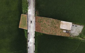 Aerial view of a concrete and asphalt landscape surrounded by green grass.