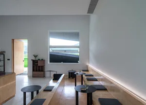 Modern cafe interior featuring minimalist design with wood, concrete, and metal elements.