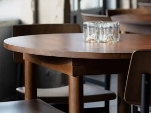 Close-up of a wooden table in a modern restaurant interior.