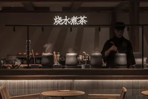 A dark, industrial-style coffee shop with wooden furniture and steaming tea kettles.
