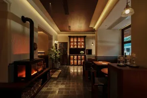 Modern restaurant bar featuring wooden accents, marble countertops, and glass cabinets.