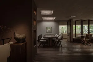 A modern restaurant dining room features a wooden table with cushions and chairs.