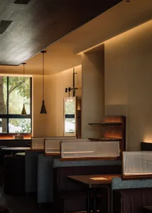 Modern restaurant interior featuring concrete materials and contemporary design elements.