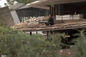 A person sitting on a wooden rooftop of a restaurant with a modern architectural design.